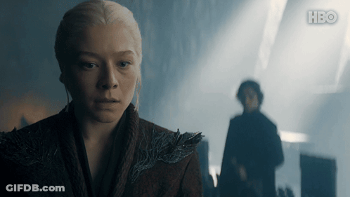 A Woman Stands In Front Of A Man In A Dark Room With Hbo Written On The Bottom GIF
