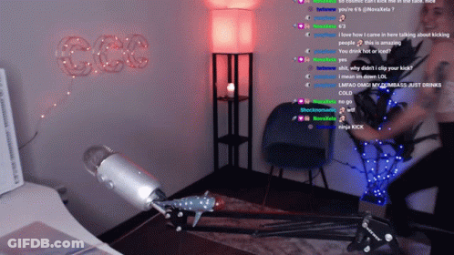 A Woman Stands In Front Of A Microphone In A Room With The Word Ccc On The Wall GIF