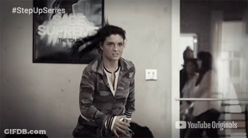 A Woman Stands In Front Of A Poster That Says " Supreme " GIF