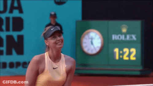 A Woman Stands In Front Of A Rolex Clock GIF