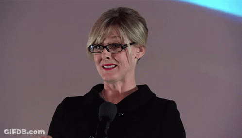 A Woman Stands In Front Of A Screen That Says Dust On It GIF