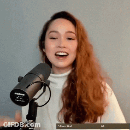 A Woman Stands In Front Of A Shure Microphone With A Follower Goal Of 548 GIF