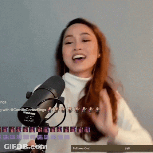 A Woman Stands In Front Of A Shure Microphone With A Follower Goal Of 548 GIF