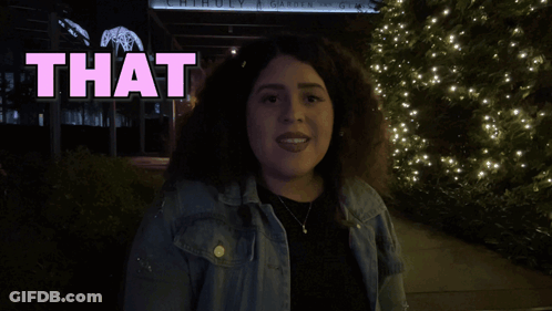 A Woman Stands In Front Of A Sign That Reads Love GIF