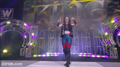 A Woman Stands In Front Of A Sign That Says King On It GIF