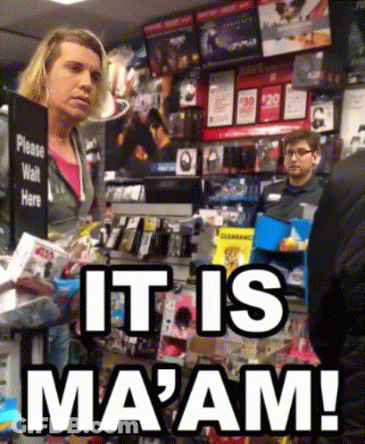 A Woman Stands In Front Of A Sign That Says " Please Wait Here " GIF
