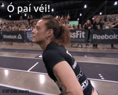 A Woman Stands In Front Of A Sign That Says Reebok On It GIF