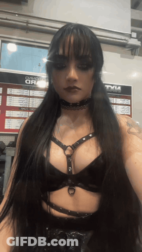 A Woman Stands In Front Of A Sign That Says Tyle On It GIF