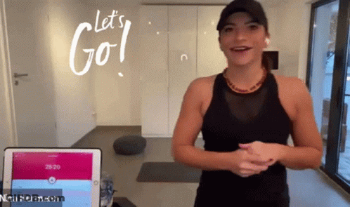 A Woman Stands In Front Of A Tablet With The Words Let 'S Go Written On It GIF