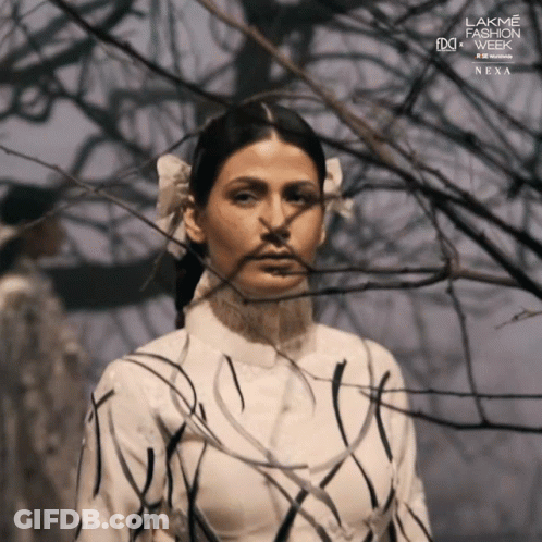 A Woman Stands In Front Of A Tree With The Words Lakme Fashion Week Next On The Bottom Right GIF