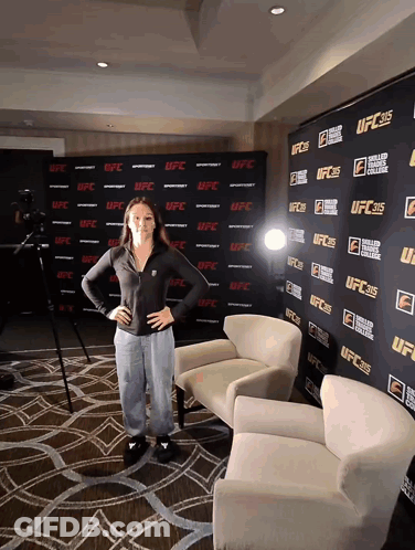 A Woman Stands In Front Of A Wall That Says UFC On It GIF