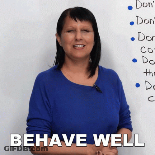 A Woman Stands In Front Of A White Board That Says Behave Well GIF