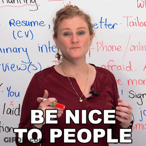 A Woman Stands In Front Of A White Board With The Words Be Nice To People On It GIF
