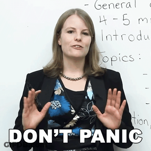 A Woman Stands In Front Of A White Board With The Words " Don 'T Panic " Written On It GIF