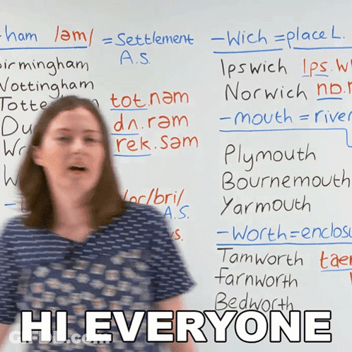 A Woman Stands In Front Of A White Board With The Words Hi Everyone Written On It GIF