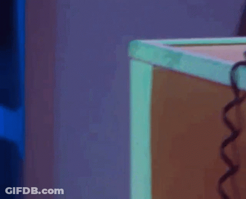 A Woman Stands In Front Of An Emergency Exit Door GIF