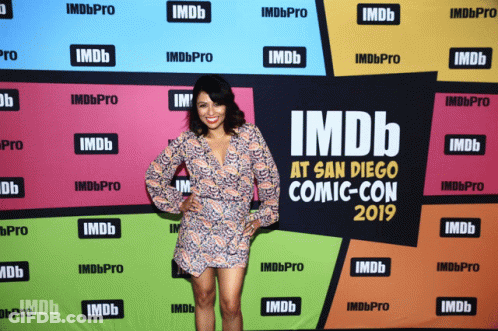 A Woman Stands In Front Of An Imdb At San Diego Comic Con 2019 Banner GIF