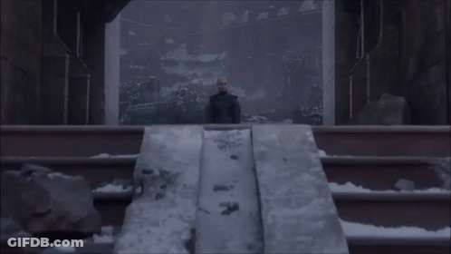 A Woman Stands On A Set Of Stairs In Front Of A Large Window GIF