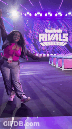 A Woman Stands On A Stage In Front Of A Twitch Rivals Arena Sign GIF