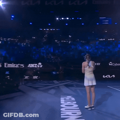 A Woman Stands On A Tennis Court In Front Of A Sign That Says ' Nba ' On It GIF