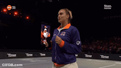A Woman Stands On A Tennis Court In Front Of A Sign That Says ' Toyam ' GIF