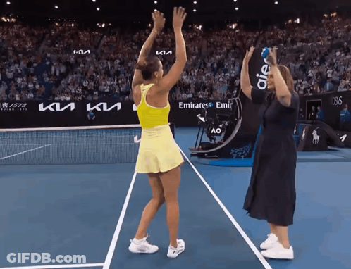 A Woman Stands On A Tennis Court With A Sign That Says Emirates Emir On It GIF