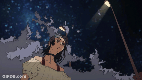 A Woman Stands Under A Street Light At Night GIF