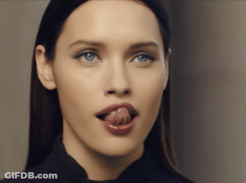 A Woman Sticking Her Tongue Out In A Close Up GIF