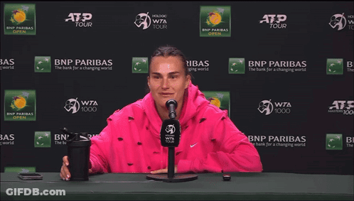 A Woman Stretches Her Leg In Front Of A Bnp Paribas Ad GIF