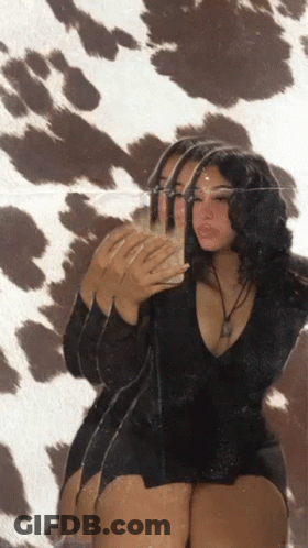 A Woman Taking A Picture Of Herself In A Mirror GIF