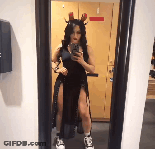 A Woman Taking A Picture Of Herself In A Mirror GIF