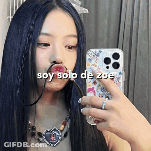 A Woman Taking A Picture Of Herself With The Words Soy Solo De Zoe On The Bottom GIF