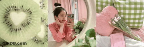 A Woman Taking A Selfie In Front Of A Mirror Next To A Slice Of Kiwi And A Book GIF
