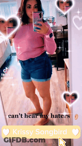 A Woman Taking A Selfie In Front Of A Mirror With Krissy Songbird In The Corner GIF