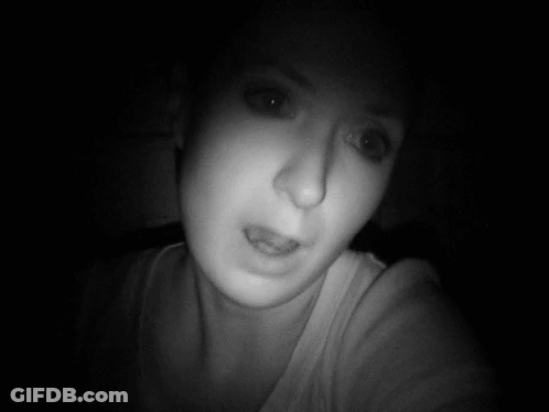 A Woman Taking A Selfie In The Dark With Her Eyes Closed GIF