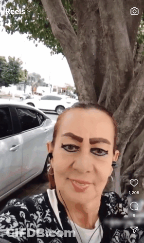 A Woman Taking A Selfie With A Car In The Background And The Word Reels On The Bottom GIF