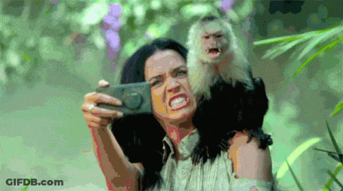 A Woman Taking A Selfie With A Monkey On Her Shoulder GIF