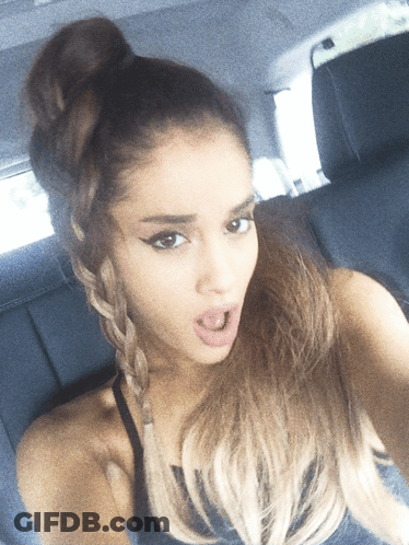 A Woman Taking A Selfie With Her Hair In A Bun GIF