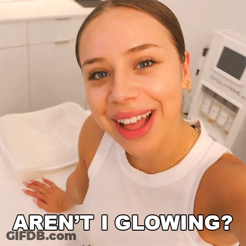 A Woman Taking A Selfie With The Words " Aren 'T I Glowing " Above Her GIF