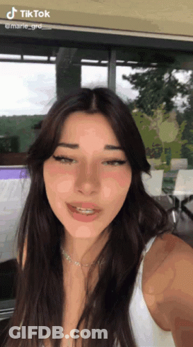 A Woman Taking A Selfie With Tiktok Written On The Bottom GIF