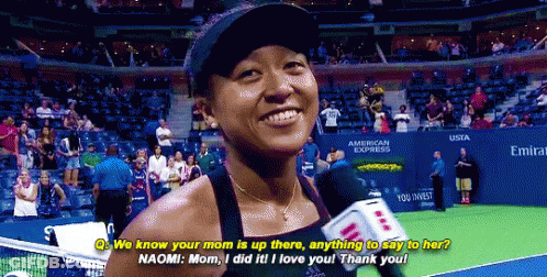 A Woman Talking Into A Microphone On A Tennis Court In Front Of An American Express Sign GIF