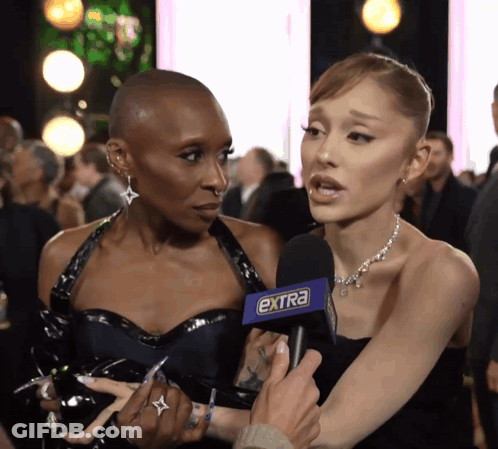 A Woman Talking Into An Extra Microphone While Another Woman Watches GIF