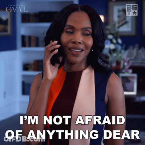 A Woman Talking On A Cell Phone With The Words I 'M Not Afraid Of Anything Dear Below Her GIF