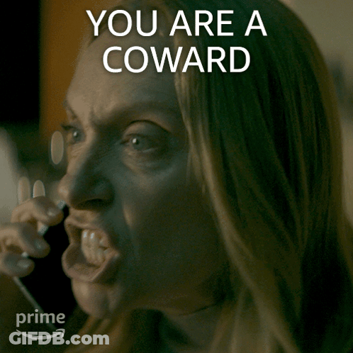 A Woman Talking On A Phone With The Words " You Are A Coward " Written Above Her GIF