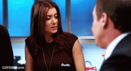 A Woman Talking To A Man With The Word Rude On Her Shirt GIF