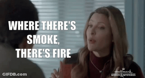 A Woman Talking To A Man With The Words " Where There 'S Smoke There 'S Fire " Above Her GIF