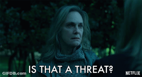A Woman Talking To Another Woman With The Words Is That A Threat Written Below Her GIF