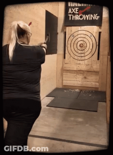 A Woman Throwing An Axe At A Target That Says Axe Throwing GIF
