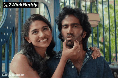 A Woman Touching A Man 'S Face With A 7Wick Reddy Watermark GIF