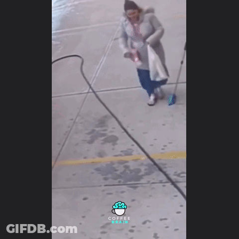 A Woman Walking Down A Sidewalk With A Coffee Bean Logo On The Bottom GIF